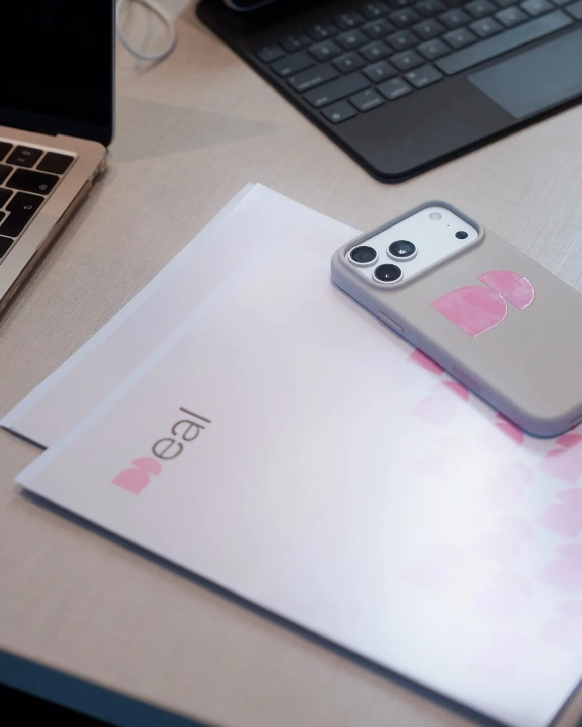 Carpeta y celular con el logotipo de Deal sobre el escritorio