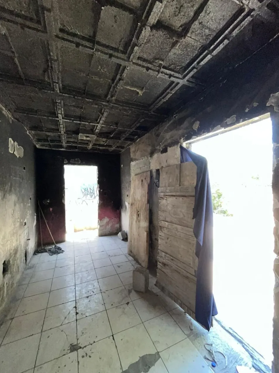 La cocina de esa casa en Escobedo, quemada, con la puerta trasera tapada con tablas