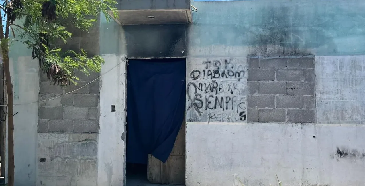 Fachada en Escobedo antes: muros de block sin acabado, grafiti y una cortina en la puerta