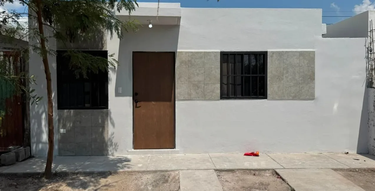 La misma fachada en Escobedo terminada, con puerta de madera y ventanas nuevas