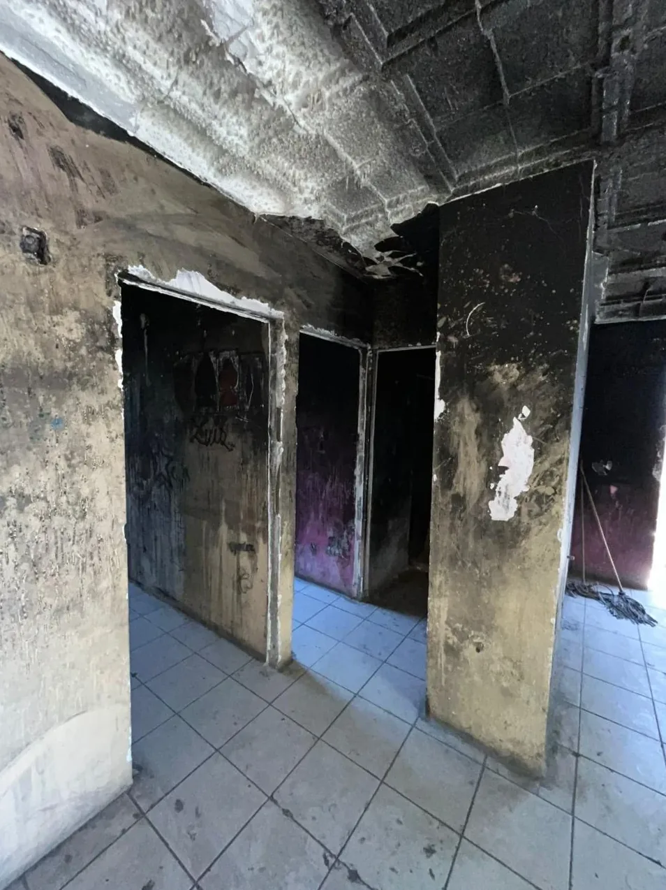 Un pasillo quemado en Escobedo: muros y techo negros de hollín y marcos de puerta ennegrecidos